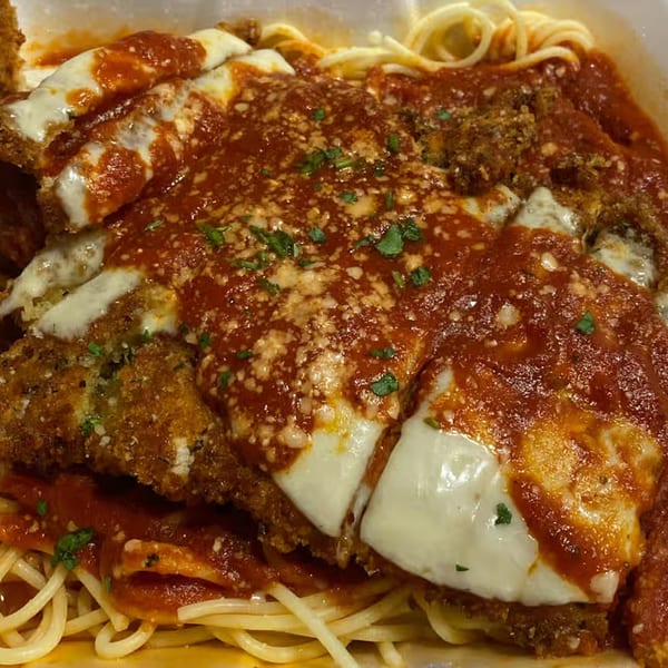 Chicken Parmesan with melted mozzarella, red sauce, and parsley over spaghetti from Patsy's Bar & Grill.